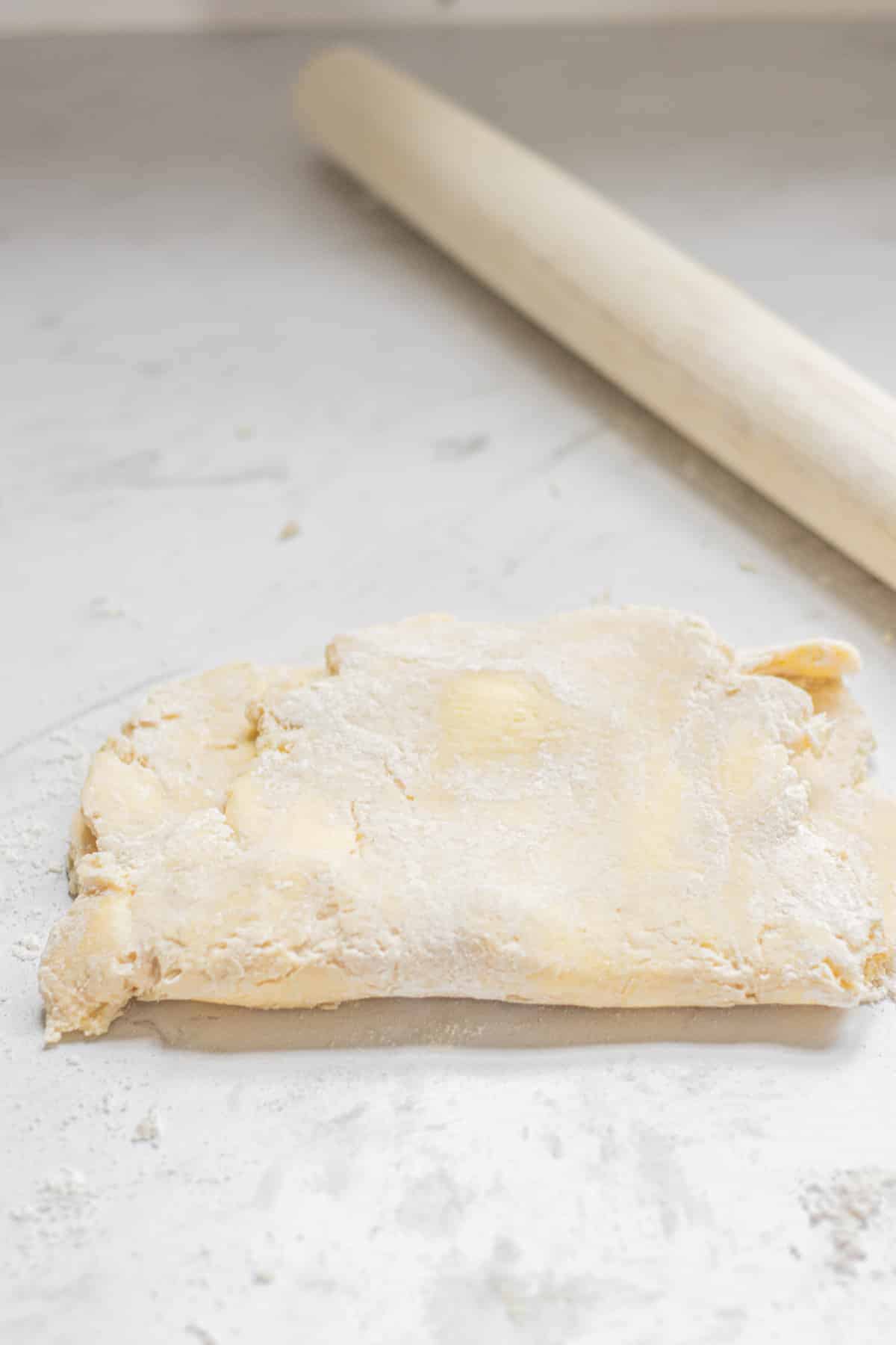 folded dough with rolling pin.