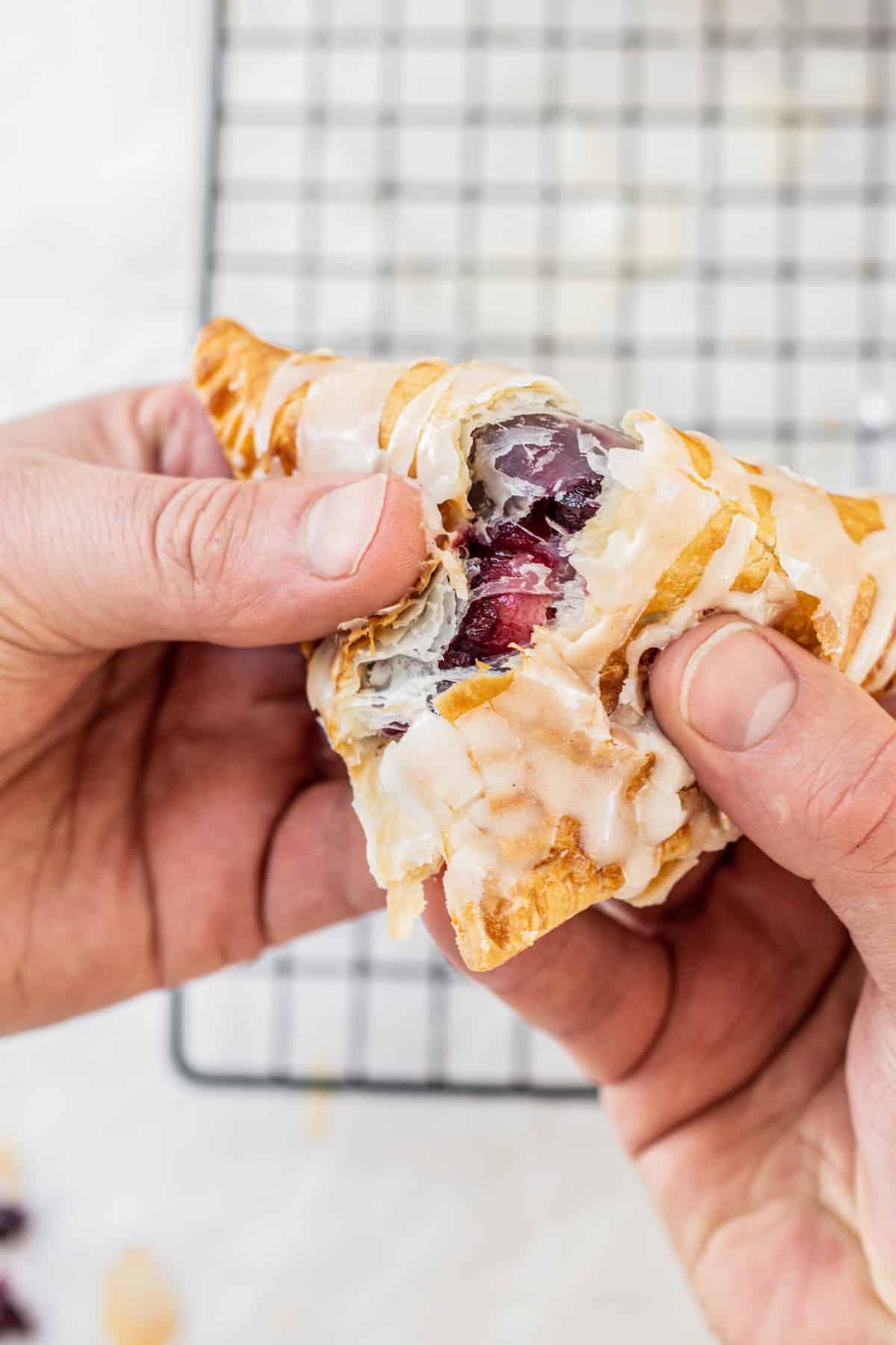 a hand tearing a turnover.