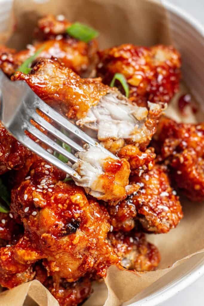 a fork with a piece of sticky chicken.